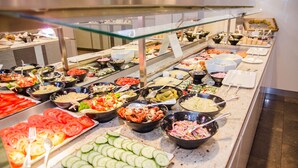 Un bufé con diversas opciones de comida, como ensaladas, carnes y verduras.