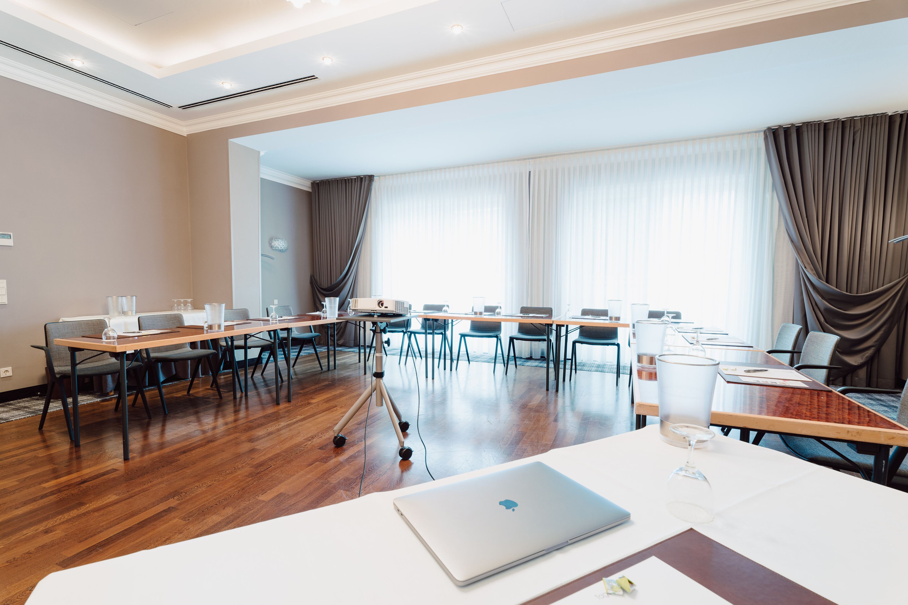 Une salle de conférence avec une longue table, des chaises et un ordinateur portable posé sur la table.