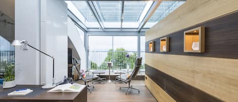 Un espacio de oficina moderno con tragaluces, paneles de madera y un escritorio con sillas de oficina.