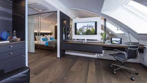 Un dormitorio moderno con cama, escritorio y televisor.