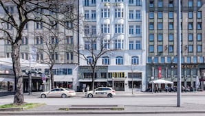 Un hotel de varios pisos con un estilo arquitectónico clásico, que presenta un letrero prominente que dice 'HOTEL', ventanas grandes y una entrada central.