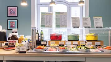 A buffet with various food items and condiments, a window with natural light, and informational signs.