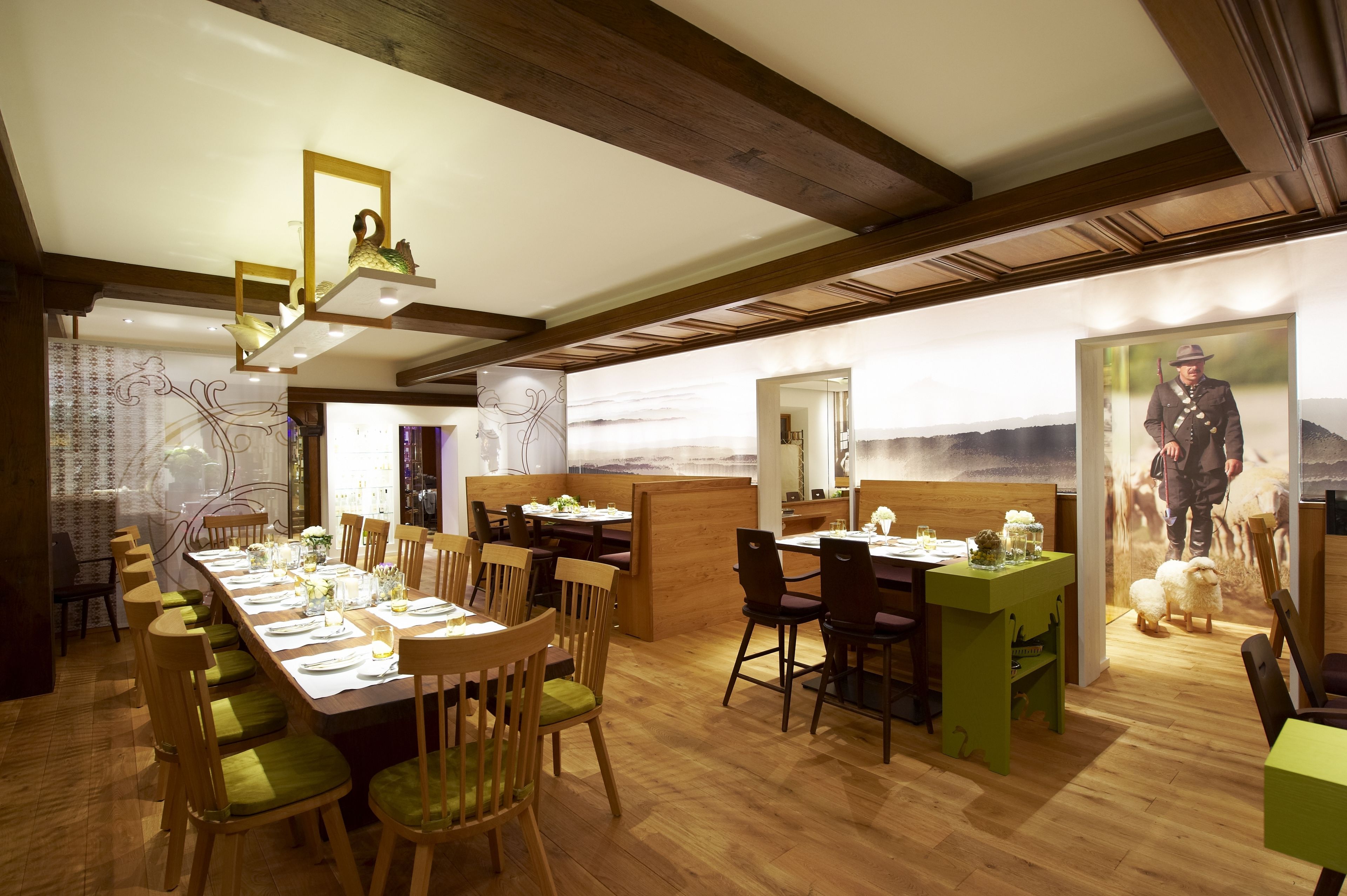 Un comedor con mesas largas, sillas y techo de madera.