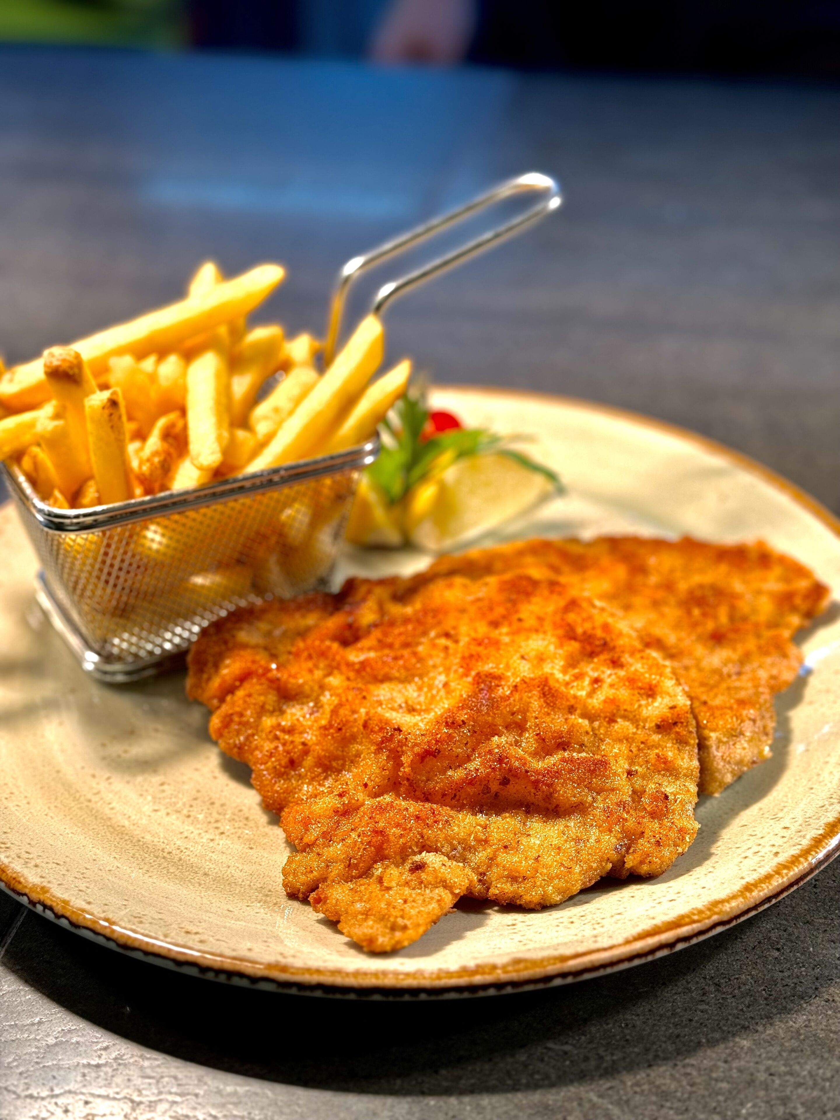 Un plato con milanesa, papas fritas y una ensalada pequeña.