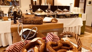 A buffet setup with various food items, including breads and pastries, and a coffee machine. - Schwanen Boutique Hotel & Restaurant Metzingen (Metzingen)