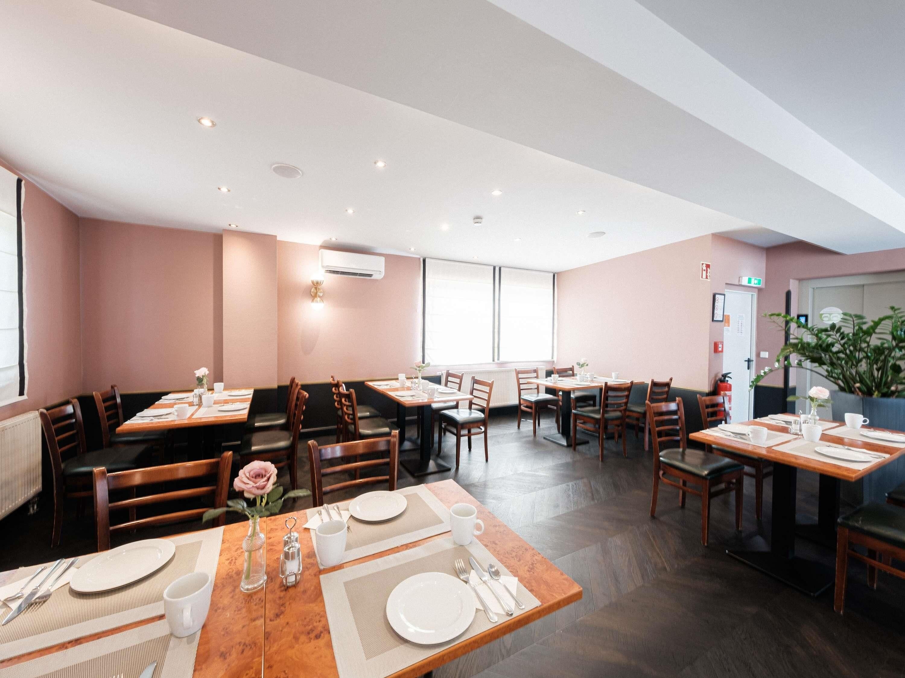 A restaurant with multiple dining tables, chairs, and a large window.