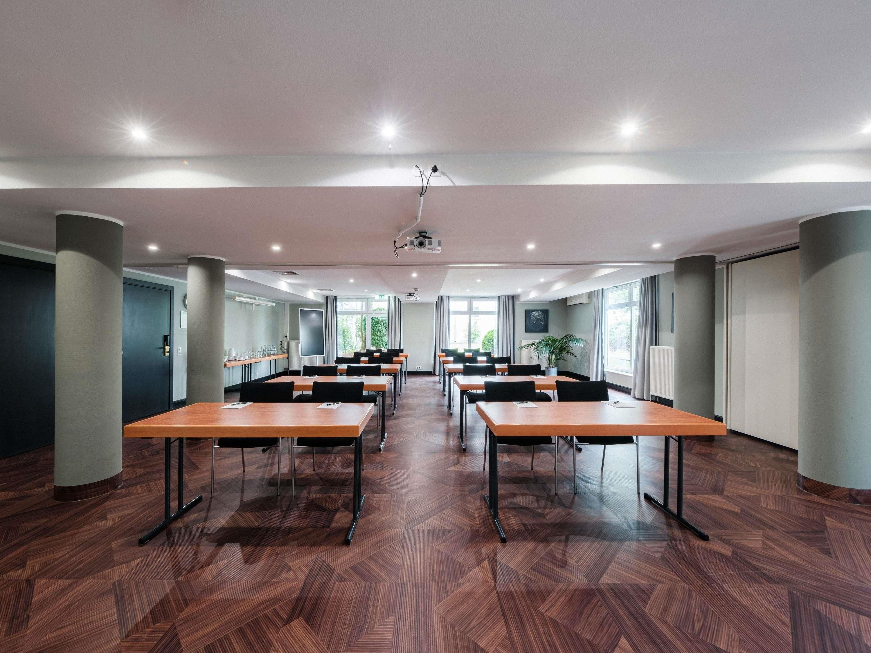 A conference room with multiple tables, a projector, and large windows.