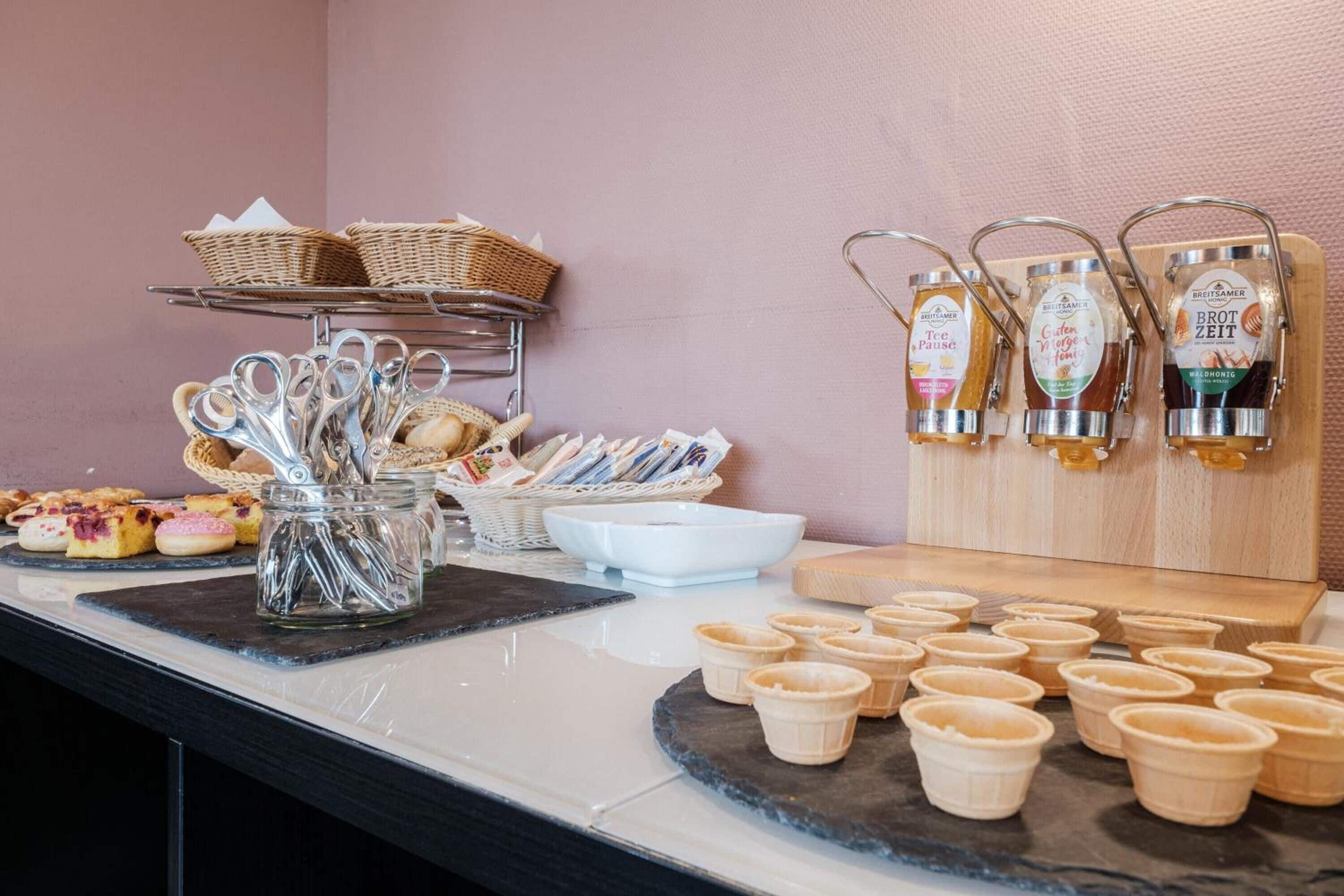 A buffet setup with various food items, baskets, and condiment dispensers.