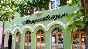 Un edificio verde con el nombre "Rappensberger" y "Castello Ristorante Pizzeria" en la fachada.