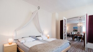 A hotel room with a bed, bedside tables, a desk, and a chair. - Hotel Haus Duden (Wesel)