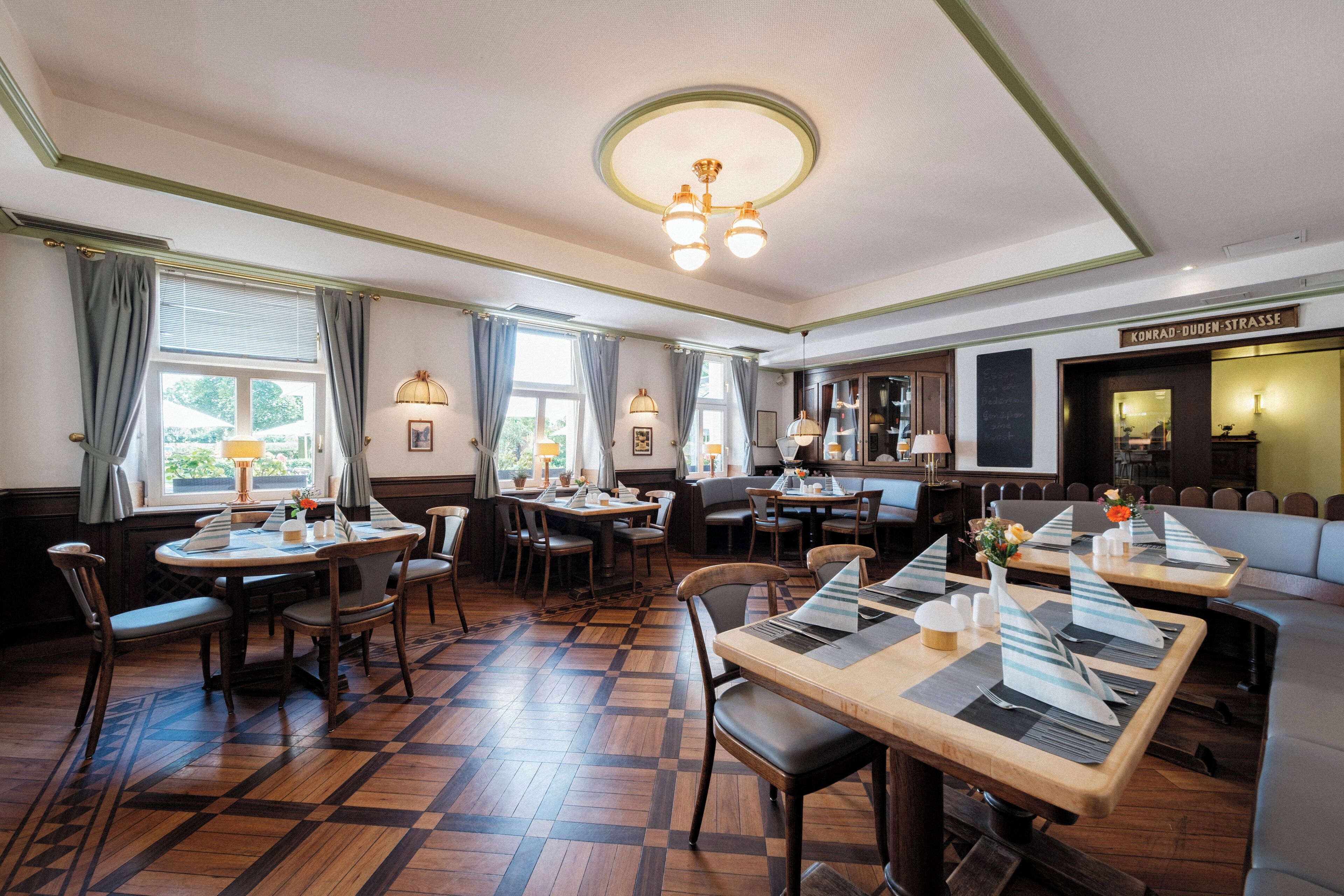 Un restaurant doté d’un plancher en bois, de plusieurs tables et de chaises.