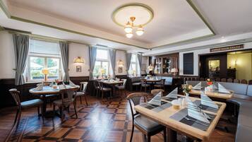 Un restaurant doté d’un plancher en bois, de plusieurs tables et de chaises.