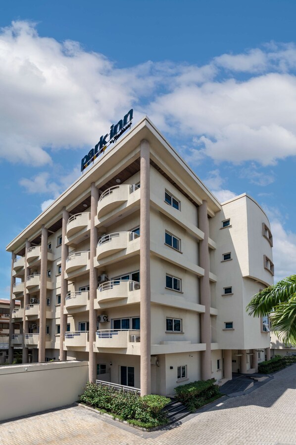 A multi-story hotel with a flat facade, balconies on each floor, and a clear sky in the background. - Park Inn by Radisson Serviced Apartments, Lagos Victoria Island (Lagos)