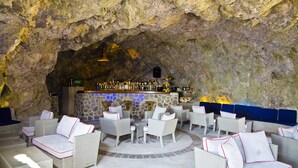 A bar area with stone walls and wicker furniture.