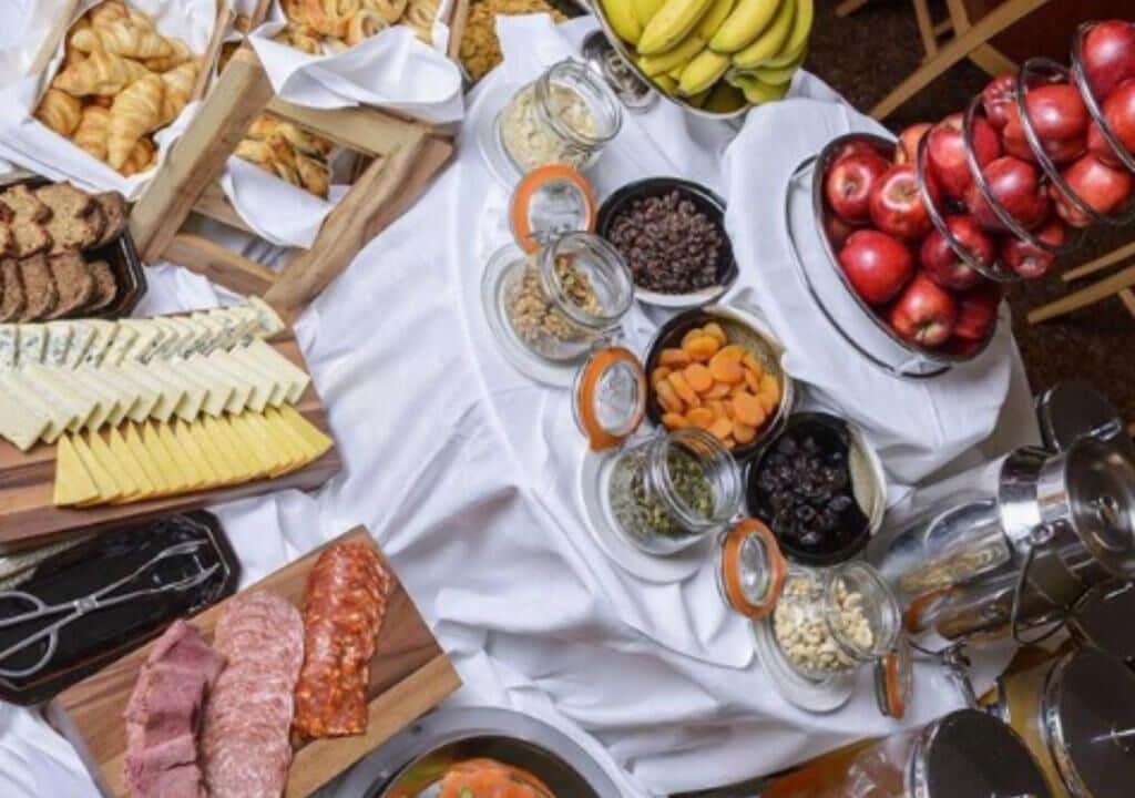 A table with various food items including cheeses, fruits, and snacks.