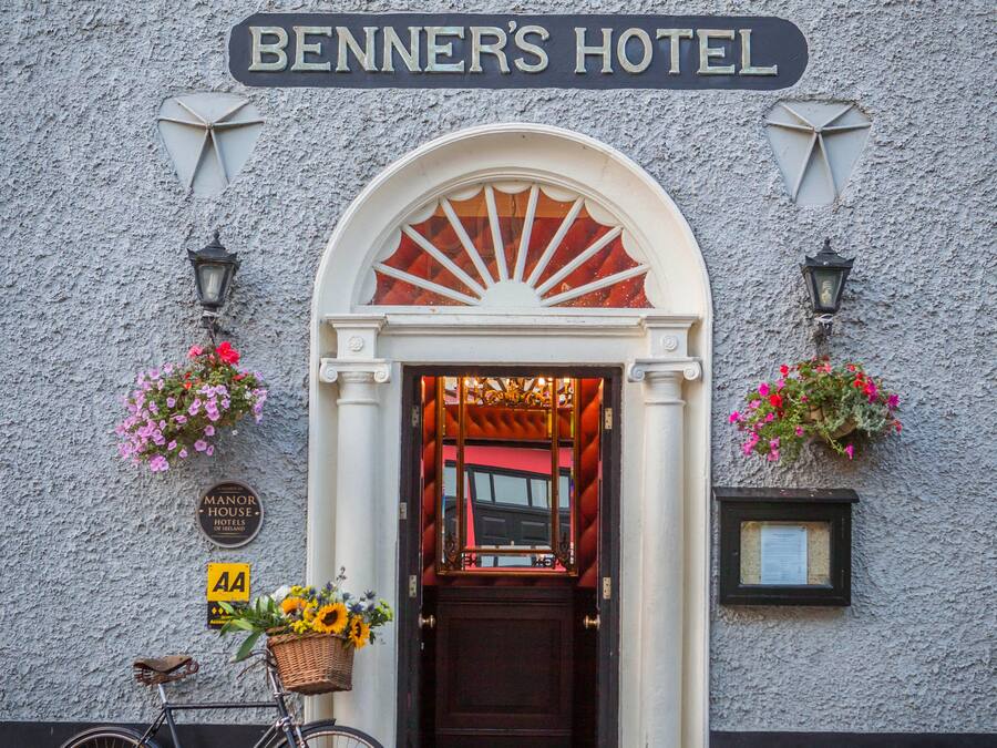 La entrada al Hotel Benner con una bicicleta estacionada afuera.