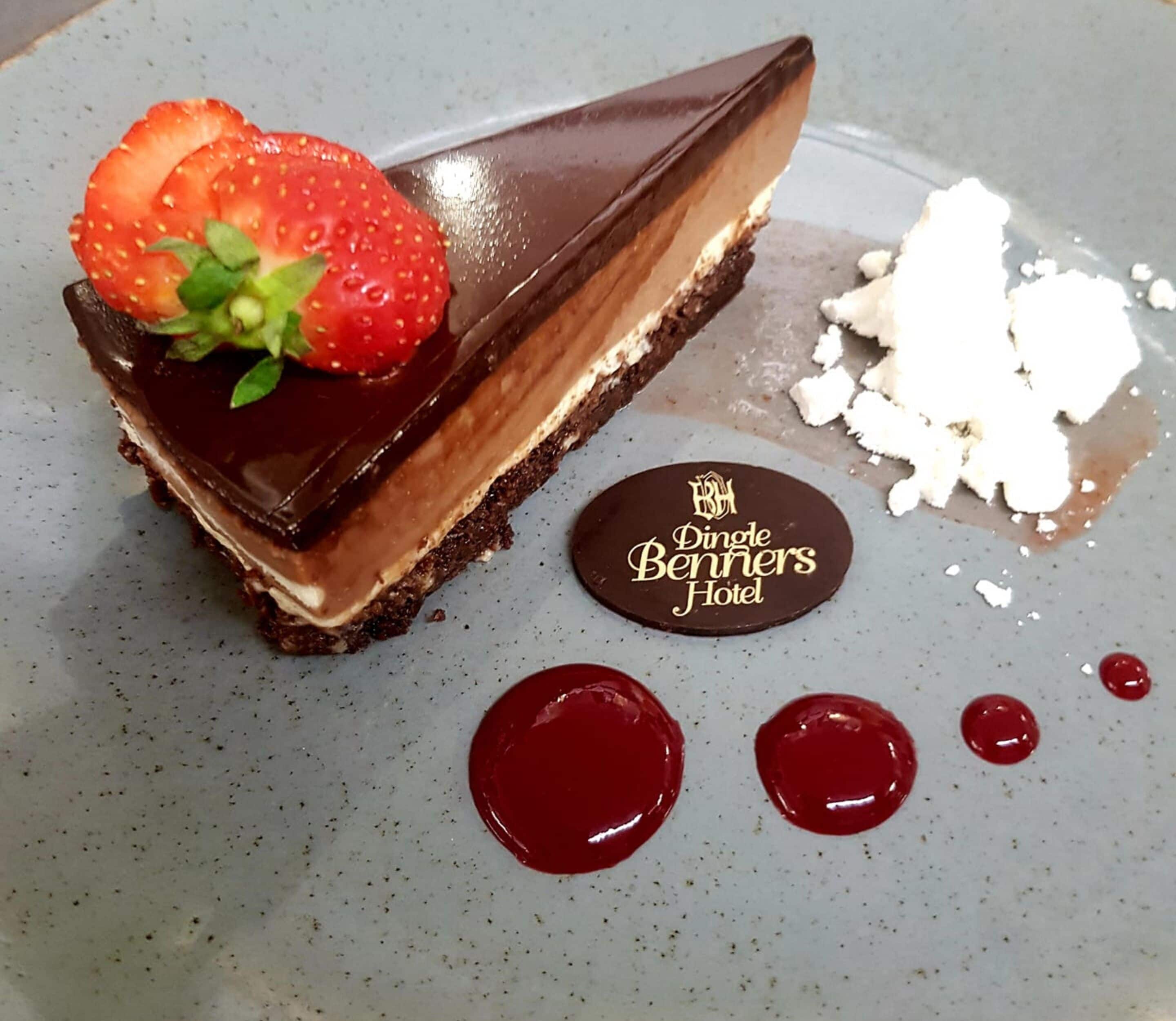Postre amb vetlla de xocolata, una fresa i un plat petit amb el text "Dingle Benners Hotel".
