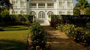 A large, white building with a symmetrical facade, multiple windows, and a central entrance.