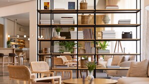 Eine moderne Bibliothek mit Bücherregalen, Sitzgelegenheiten und einer Kaffeebar.