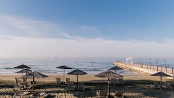 On the beach, white sand, sun loungers, beach umbrellas