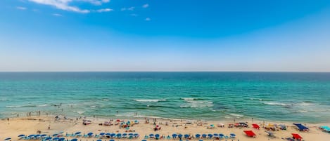 On the beach, white sand, sun loungers, beach umbrellas