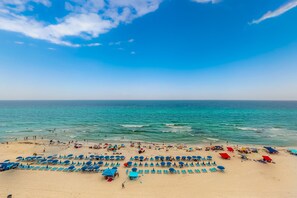 A beach with rows of sun loungers and umbrellas, a sandy shore, and the ocean in the background. - Celadon Beach Resort (Panama City Beach)