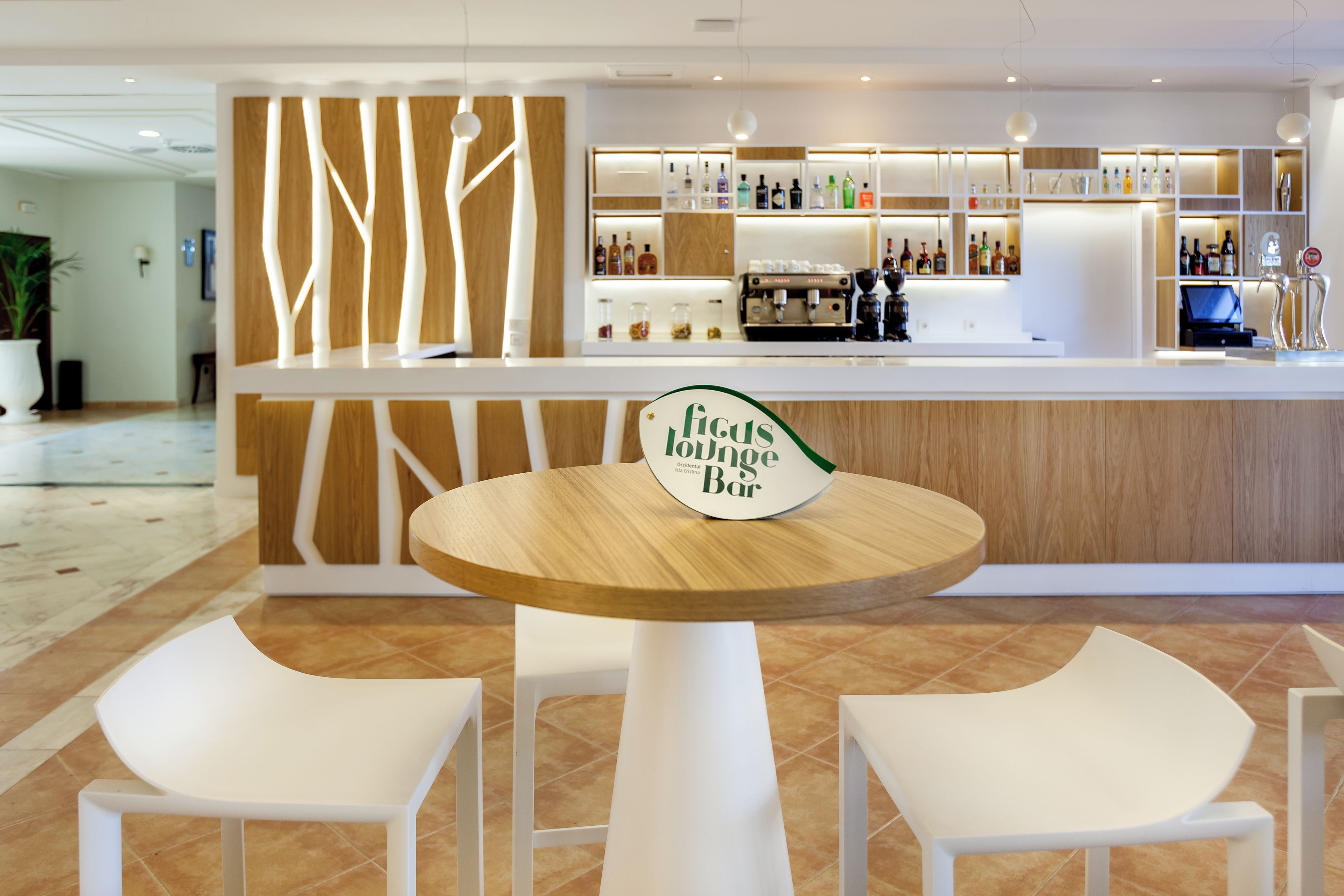 A bar area with a sign reading 'Ficus Lounge Bar' and a coffee machine.