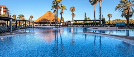 Una piscina al aire libre, sillones reclinables de piscina