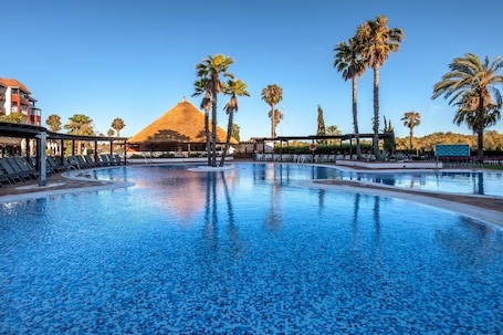 Una piscina al aire libre, sillones reclinables de piscina