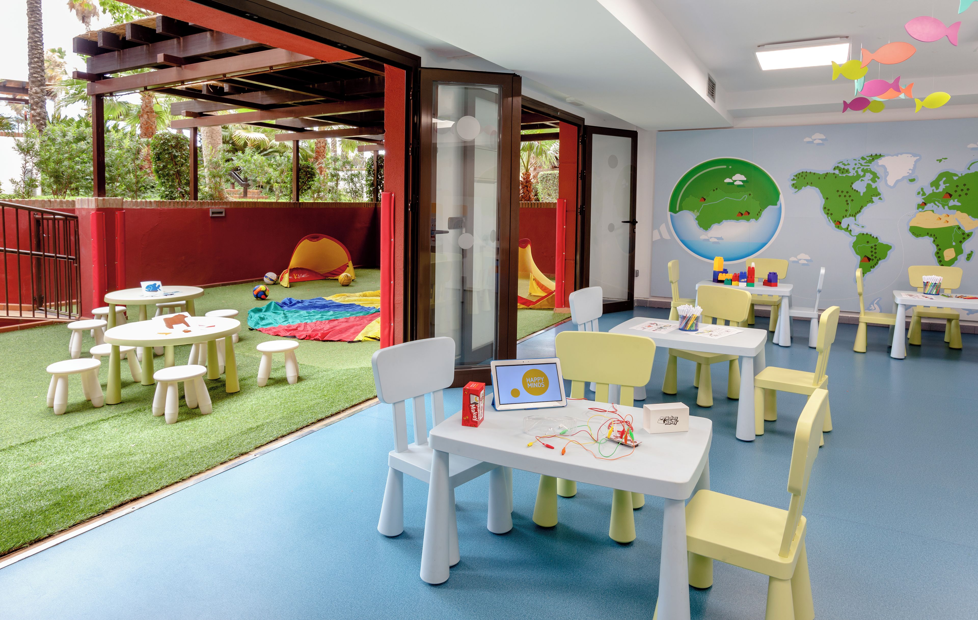 A children's play area with tables, chairs, and a slide.