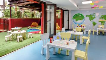 A children's play area with tables, chairs, and a slide.