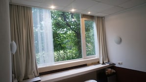 A room with a large window, a radiator, a desk, and a chair. - The Budget Hotel (Hazerswoude-Rijndijk)