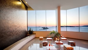 Un vestíbulo amplio con una gran vista al mar, mobiliario de vidrio transparente y un diseño moderno.