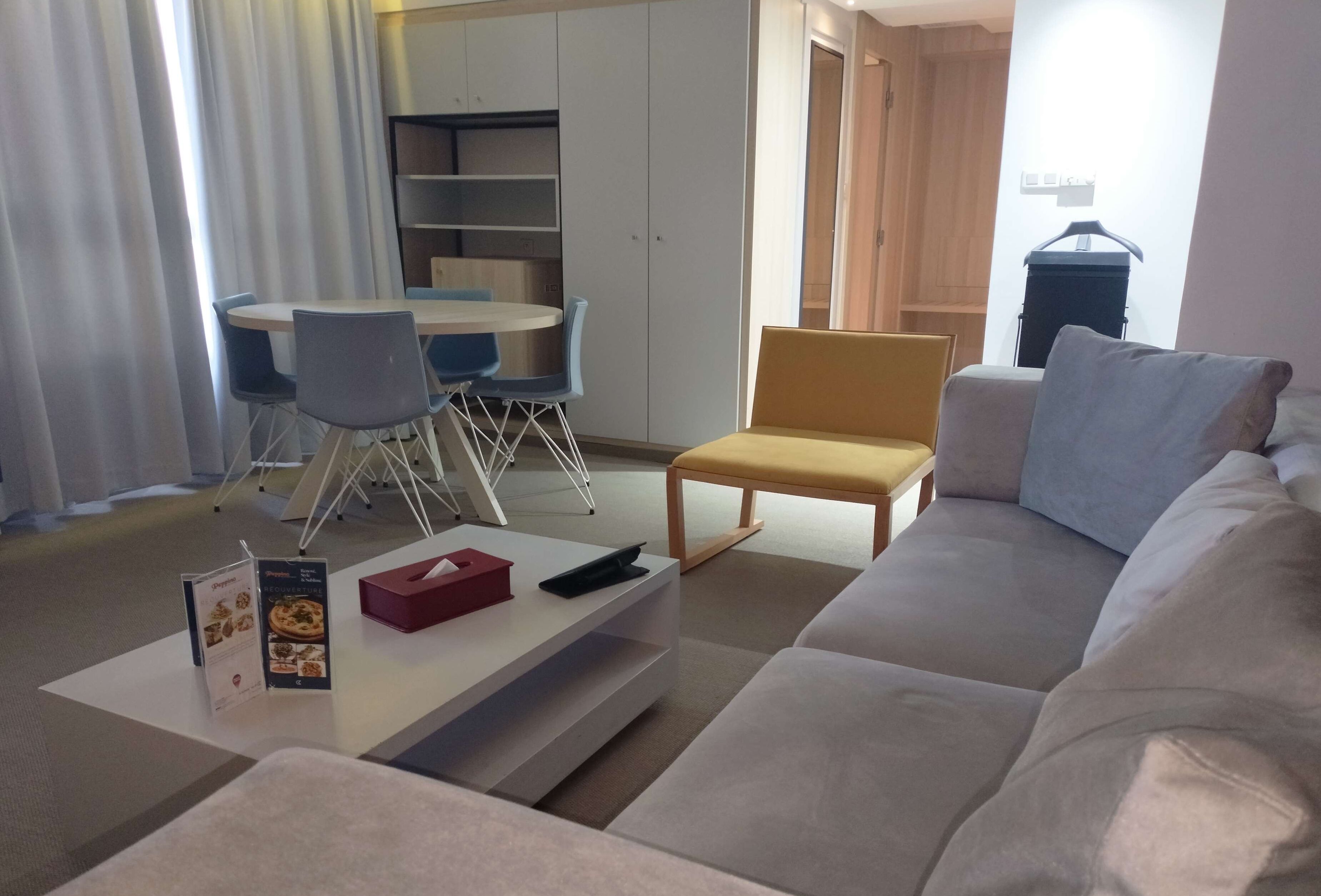 Una sala moderna con sofá, una mesa de centro y un comedor con mesa y sillas.