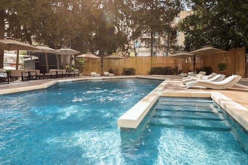 Una piscina al aire libre, tumbonas