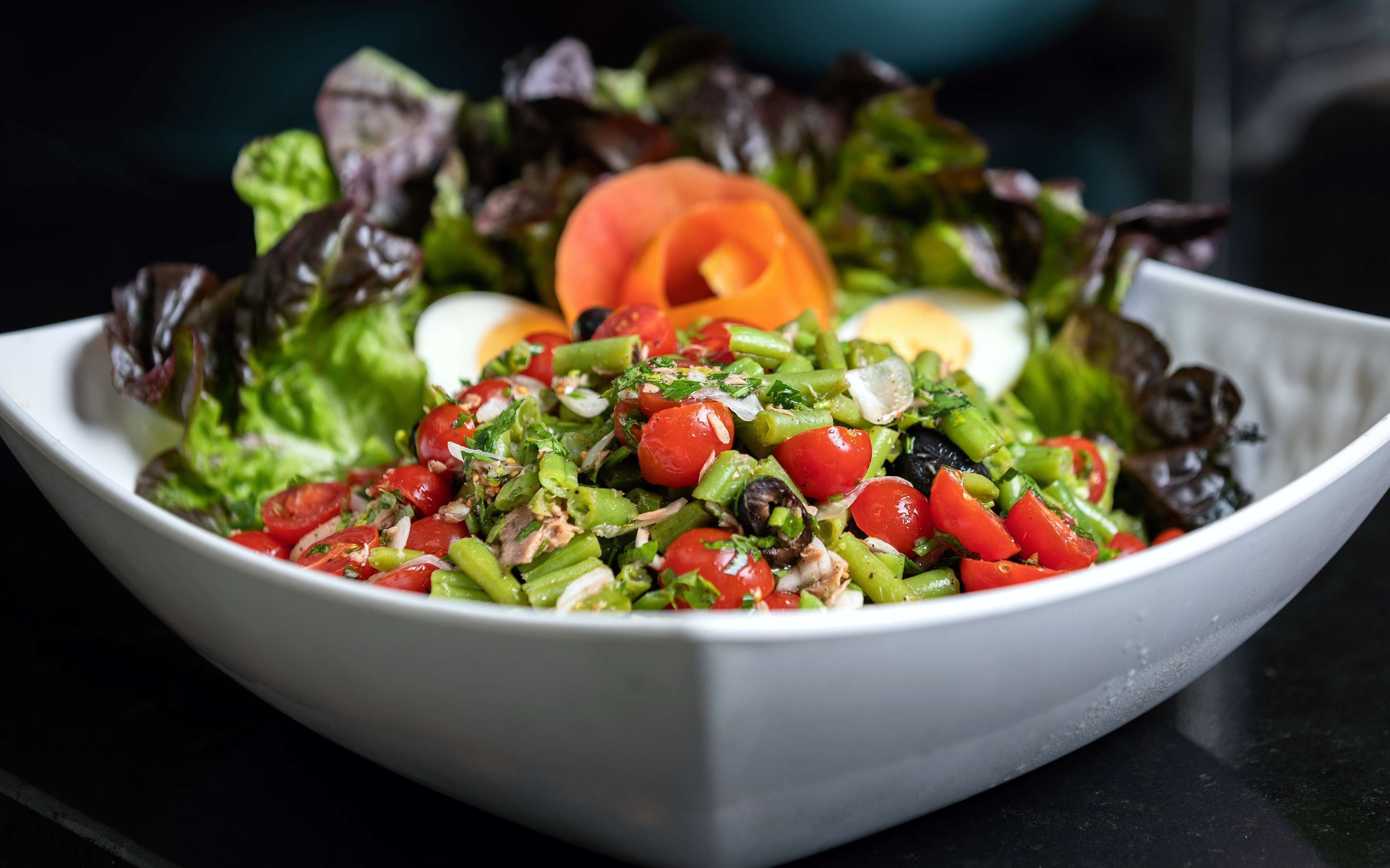 Un saladier de salade composée, avec divers légumes et un œuf dur.