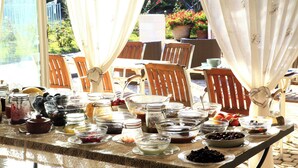 Un bufé de desayuno con diferentes opciones de comida y vistas al jardín.