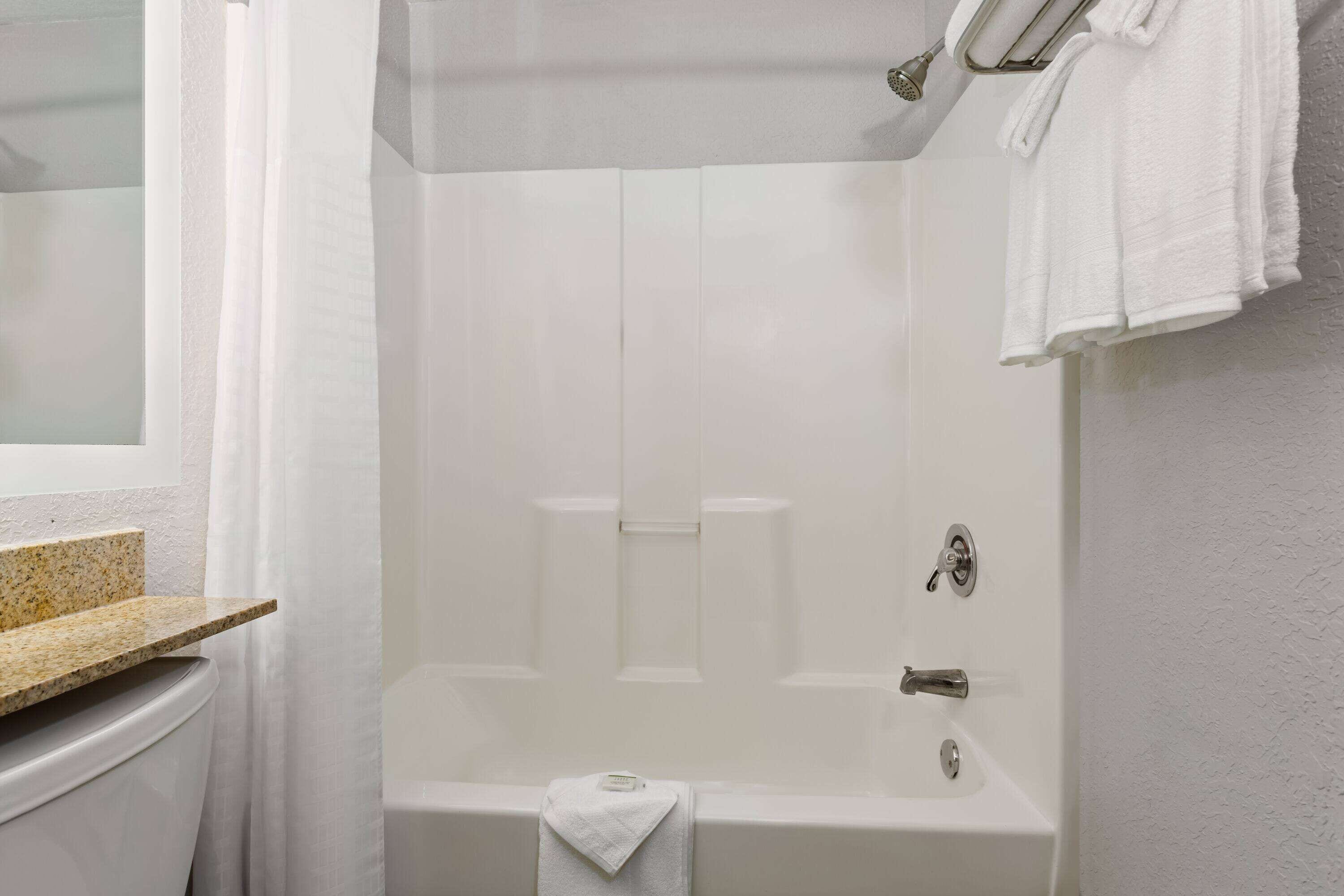 A bathroom with a bathtub, a toilet, and a sink.