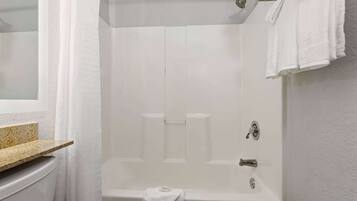 A bathroom with a bathtub, a toilet, and a sink.