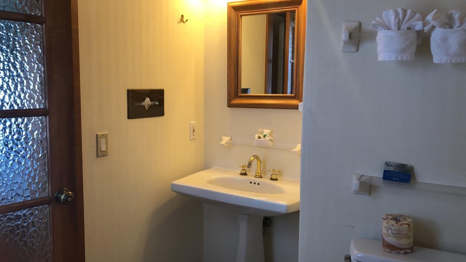 A bathroom with a white sink, a mirror, and a towel rack.