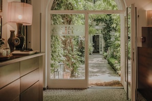 Une porte donnant sur un jardin, avec une pancarte indiquant « Bienvenue ».
