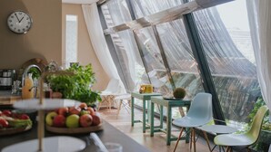 Una cocina moderna con un amplio ventanal, un reloj y un frutero.