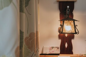 Um quarto com um candeeiro pendurado, um armário de madeira e um cartaz na parede.