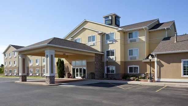 A hotel with a covered entrance, multiple windows, and a stone facade.