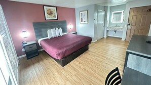 A bedroom with a bed, bedside tables, a desk, and a chair. - Ocean Gate Inn (Santa Cruz)