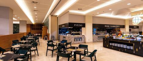 Un restaurante moderno con varias zonas de comedor, una barra central con diversos productos alimenticios, y secciones claramente identificadas para pizzas y otros platos.