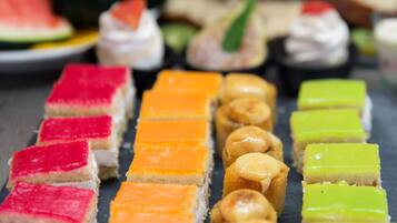 Verschillende kleurrijke desserts gerangschikt op een leistenen dienblad.