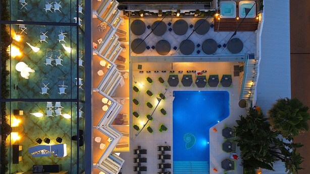 An aerial view of a hotel pool area with multiple seating areas, a swimming pool, and a sun terrace. - Essence Hotel Boutique (Torremolinos)