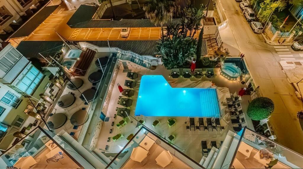 Un espace piscine aménagé sur le toit, avec des chaises longues et une piscine.