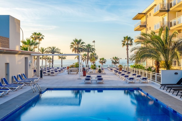 Piscine extérieure, parasols de plage, chaises longues